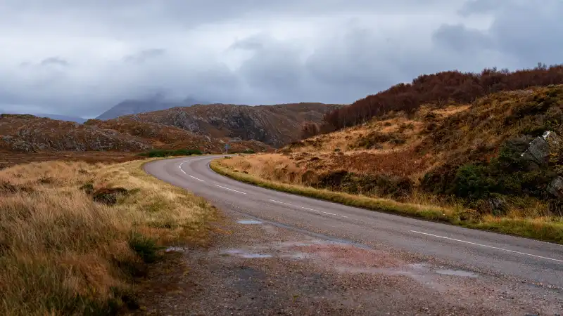 Smalle weg door de Schotse Highlands met bergen