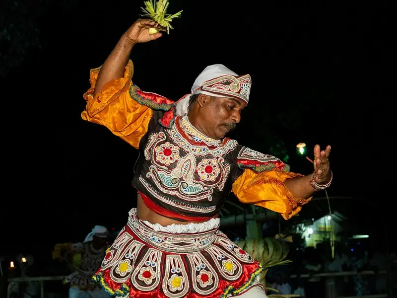 Dansers in kleurrijke kostuums bij een Kandy-dansshow