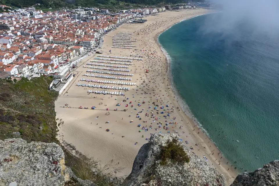 Het brede strand en de stad Nazaré gezien vanaf de Sítio-klif